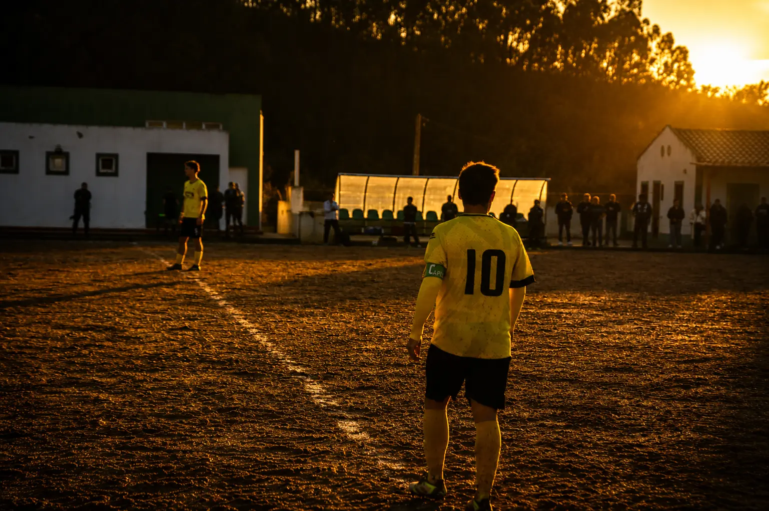 Jogador do FC Pereirense em campo ao pôr do sol, no Estádio Municipal de Pereira